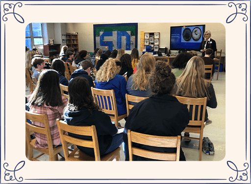 Kids in a classroom watching presentation with Dr. Holland